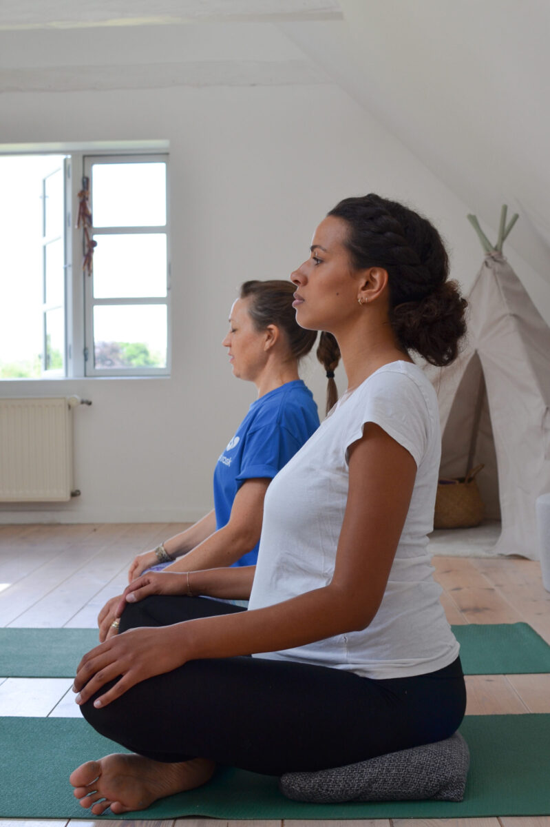 Gravid kvinde laver yoga - hjemme ved sig selv