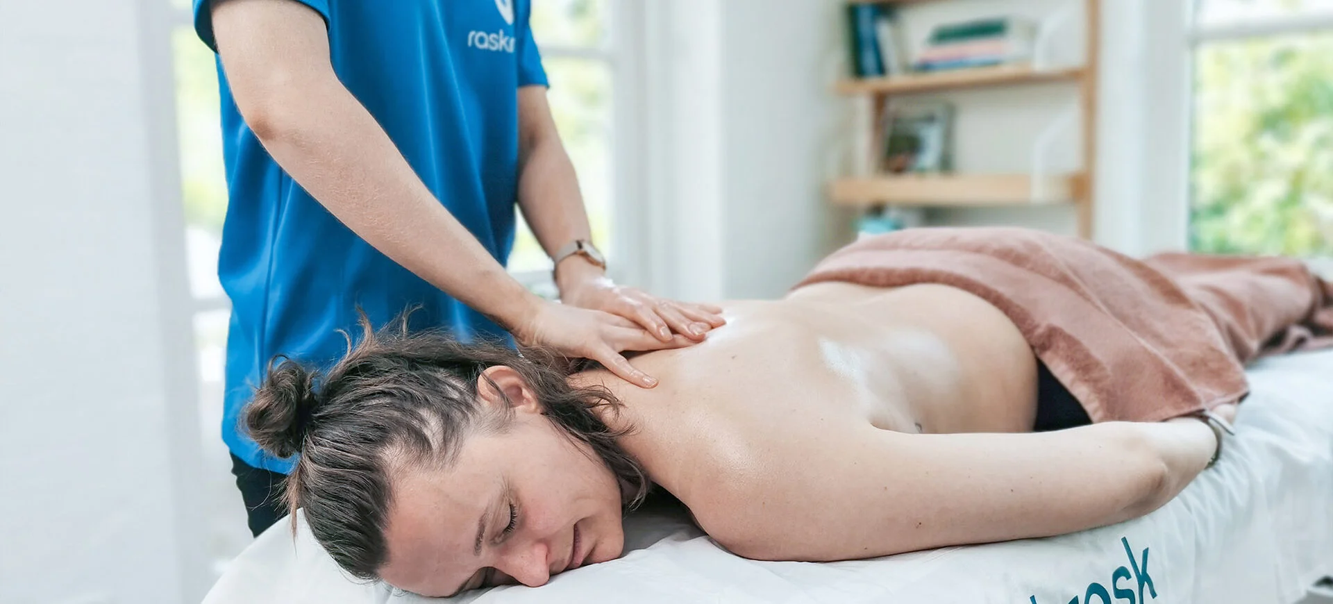Massør giver kunde massage på briks