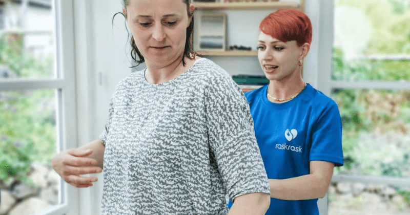 Kvinde får konsultation med massør omkring tennisalbue